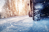 Car tires on winter road covered with snow