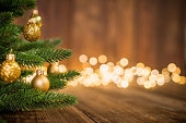 Fir Tree decorated with christmas balls on rustic wood and sparkles light background