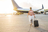 Back view of a woman walking towards the plane, ready to board and begin her vacation