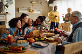 Cheerful multiracial family having fun while gathering for Thanksgiving at home.