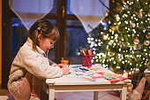 Little girl making Christmas card.