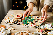 Woman hands arranging sweets on Christmas table