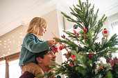 Family decorating Christmas tree at home