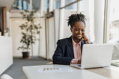 Businesswoman Smiling While Working at Her Laptop