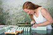 Woman cutting pieces of handmade organic soap in her shop