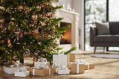 Close-up Of Christmas Tree And Gift Boxes In Living Room With Blurred Background
