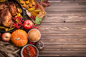 Traditional Thanksgiving still life. Roasted turkey, pumpkin pie, cranberries, autumn pumpkins and nuts on a dark wooden table. Top view. Holiday concept
