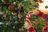 Child decorating Christmas tree with gingerbread cookies