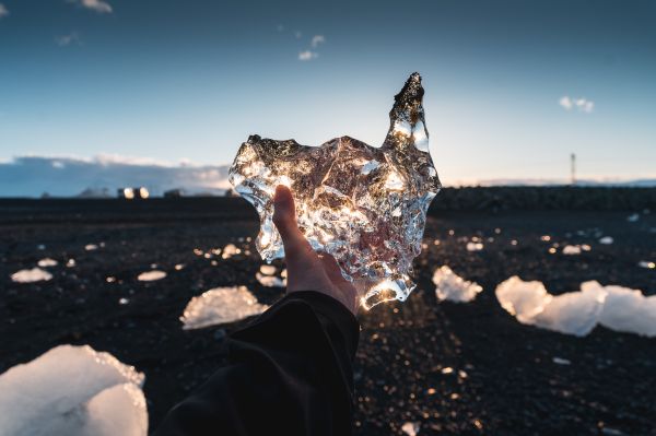 Man Holding a Piece of Ice from Diamond Beach in Iceland Free Photo